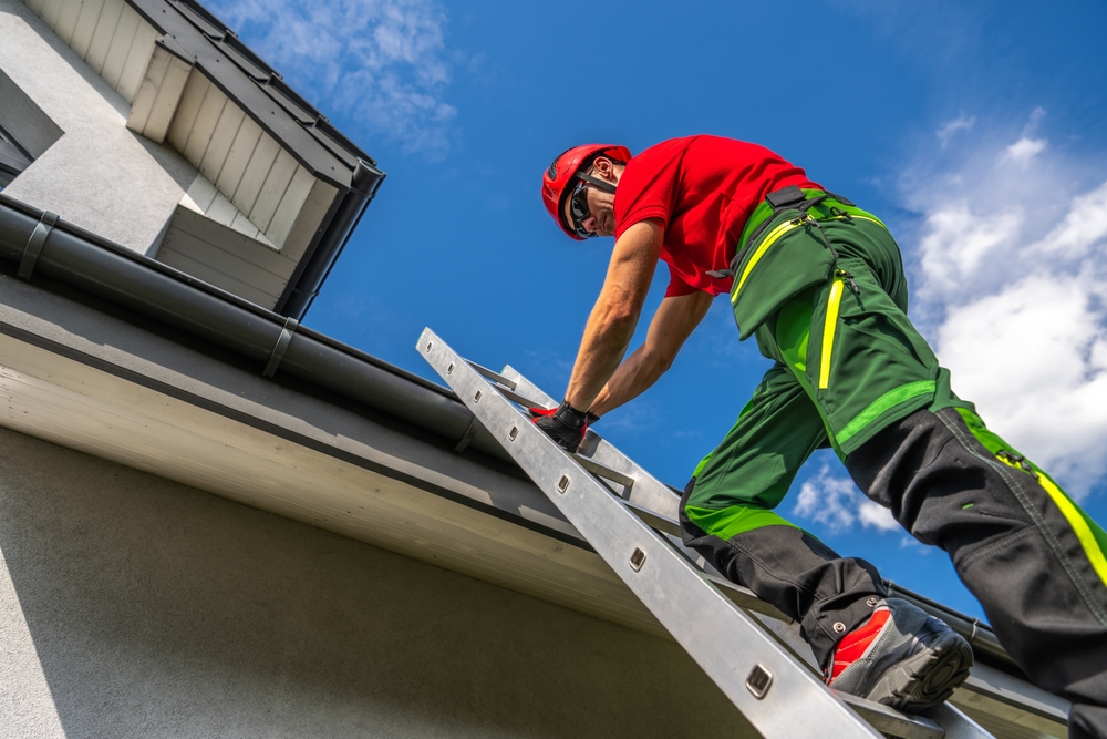 A,maintenance,worker,in,safety,gear,ascends,a,ladder,to